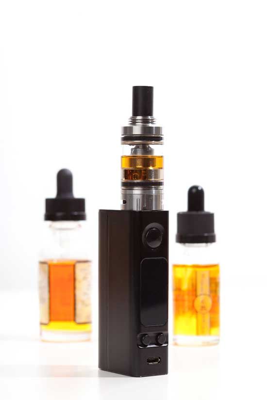 A black cannabis vaporizer with amber oil cartridge and two tincture bottles.